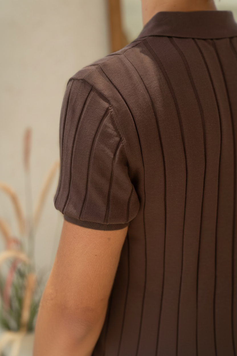Brown pleated shirt worn by a person with a blurred background