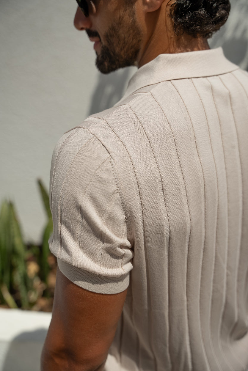 Man wearing a beige short-sleeve shirt with a blurred background